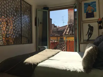 a bedroom with a bed and a window with a view at Spacious and bright flat close to the beach : heart of old Nice in Nice