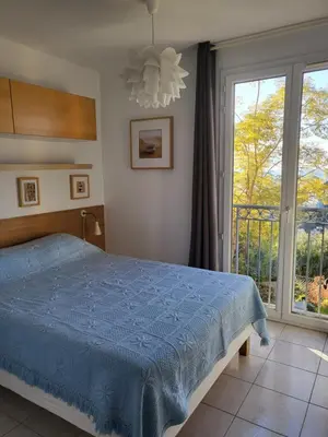 a bedroom with a blue bed and a window at Nice garden in Nice