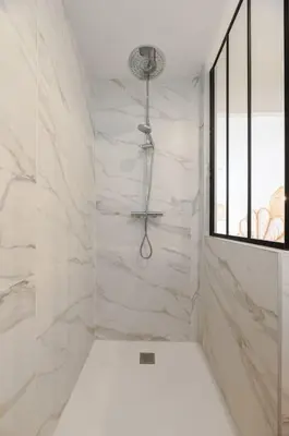 a bathroom with a shower with white marble walls at A/C & BALNEO in of Carré d'Or NICE #RENOVATED in Nice