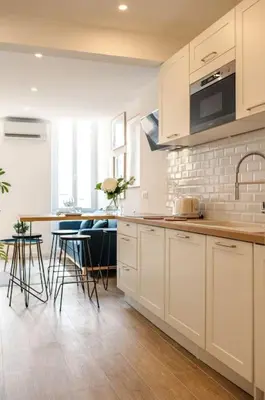 a kitchen with white cabinets and a table and chairs at A/C & BALNEO in of Carré d'Or NICE #RENOVATED in Nice
