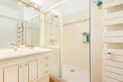 a white bathroom with a shower and a sink at Eat - Sleep - Wander Chic and Cosy Flat in Nice