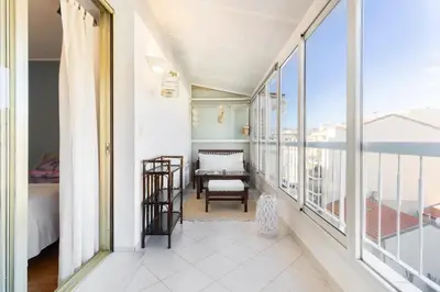 a room with a balcony with a bed and a table at Eat - Sleep - Wander Chic and Cosy Flat in Nice