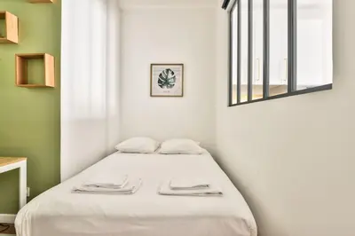 a bed in a white room with a window at Magnificent apartment - Carré d'or in Nice