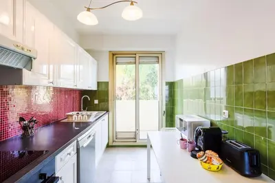 a kitchen with green tiles and a white counter top at LE SIRIUS AP4314 By Riviera Holiday Homes in Nice