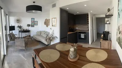 a living room with a dining table and a kitchen at Appartement de luxe Eze village vue mer avec piscine in Èze