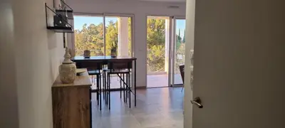 a dining room with a table and chairs and a glass door at Appartement de luxe Eze village vue mer avec piscine in Èze