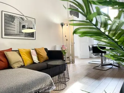 a living room with a couch and a table at Homelivia, VIEUX NICE, appartement de charme, clim balcon in Nice
