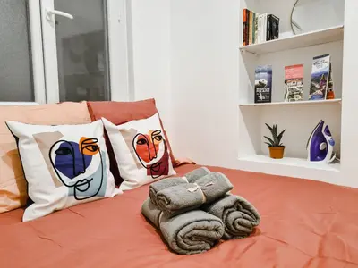 a bed with a bunch of pillows on it at Cosy studio VIEUX NICE à 2 pas de la MER in Nice