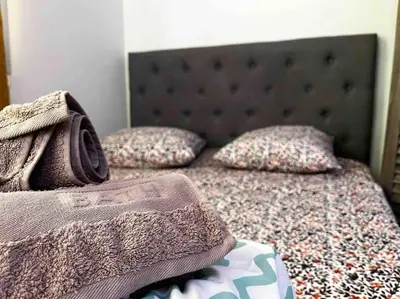 a bed with two pillows on top of it at Parking + piscine, tout confort, proche aéroport & mer in Saint-Laurent-du-Var