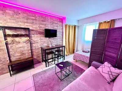 a living room with a couch and a table at Parking + piscine, tout confort, proche aéroport & mer in Saint-Laurent-du-Var
