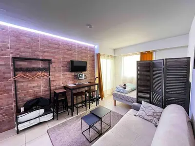 a living room with a couch and a dining room at Parking + piscine, tout confort, proche aéroport & mer in Saint-Laurent-du-Var