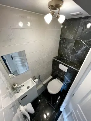 a bathroom with a toilet and a sink and a mirror at Appartement bord de mer avec piscine in Saint-Laurent-du-Var