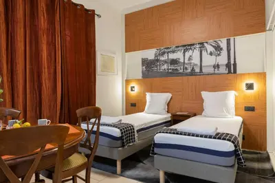 a hotel room with two beds and a table at La plume de Paul in Nice