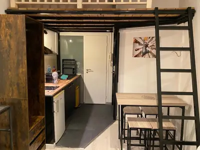 a kitchen with a loft bed and a table and chairs at Rentomatique Studio Jean Médecin in Nice