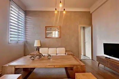 a living room with a table and a couch and a tv at Au Petit Bourgeois in Nice
