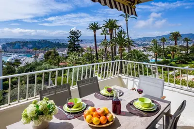 a table with a bowl of fruit on a balcony at Ferienwohnung Les Oliviers über den Dächern von Nizza ruhig sonnig Meerblick Pool Tiefgarage Parkplatz in Nice