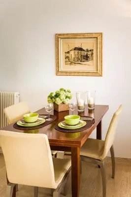 a dining room table with two chairs and a picture at Ferienwohnung Les Oliviers über den Dächern von Nizza ruhig sonnig Meerblick Pool Tiefgarage Parkplatz in Nice