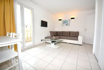 a living room with a couch and a glass table at Palais des Domes Piscine et Parking in Nice