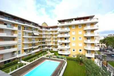 an apartment building with a swimming pool in front of it at Palais des Domes Piscine et Parking in Nice