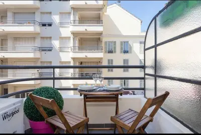a balcony with a table and chairs and a building at Royal apartment near the beaches in Nice
