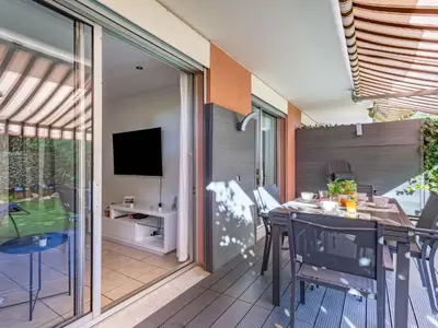 a patio with a table and chairs and a television at Apartment Le Marbeau-2 by Interhome in Cagnes-sur-Mer