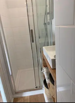 a shower with a glass door next to a sink at Studio Nice Le Palais, avec cuisine et espace repas séparés, dans immeuble niçois, Port de Nice, Vieux Nice, Place du pin et Garibaldi, Colline du château, à 2 minutes de la promenade des Anglais in Nice