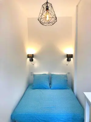 a bedroom with a blue bed with two blue pillows at Homelivia, Votre Appartement ideal pour découvrir Nice in Nice