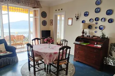 a dining room with a table with a vase of flowers on it at Vintage flat on Villefranche bay - free car park in Villefranche-sur-Mer