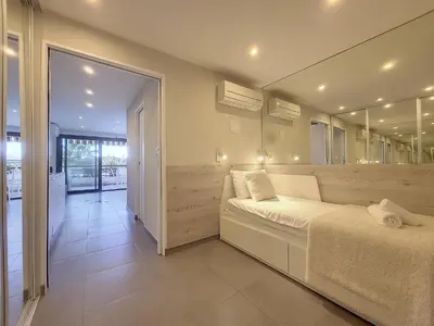 a bedroom with a white bed and a large mirror at Nestor&Jeeves - GRAND SUD TERRASSE - Pool - Free parking in Nice