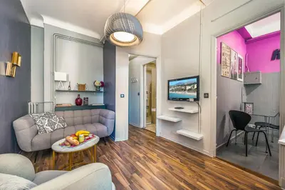 a living room with a couch and a tv at LX191 2P design & coloré face gare - Balcon & clim in Nice