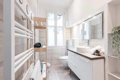 a bathroom with a toilet and a sink and a window at Lovely 1 Bdr in Harbor Area in Nice