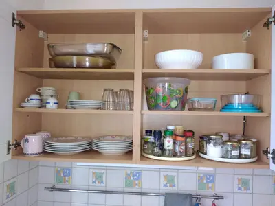 a kitchen cabinet filled with plates and dishes at NICE NORD 2 PIECES CALMES,WIFI,CLIM,BALCON,PARKING in Nice