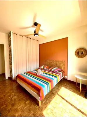 a bedroom with a bed with a colorful striped blanket at Cosy Californie in Nice