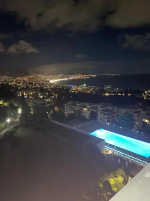 a view of a city at night with a swimming pool at NICE BAIE DES ANGES in Nice