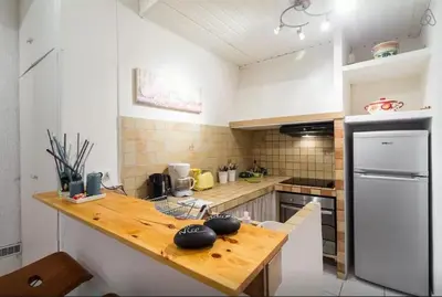 a kitchen with a wooden counter top and a refrigerator at St Joseph · Great holiday flat - old town for 4 in Nice
