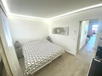 a bedroom with a bed with a black and white comforter at Magnifique appartement les pieds dans l’eau à Nice in Saint-Laurent-du-Var