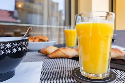 a glass of orange juice sitting on a table at #4 Papon Parking climatisé terrasse & wifi 5mins à pieds du Vieux Nice in Nice
