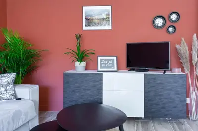 a living room with a black and white desk with a tv at #4 Papon Parking climatisé terrasse & wifi 5mins à pieds du Vieux Nice in Nice