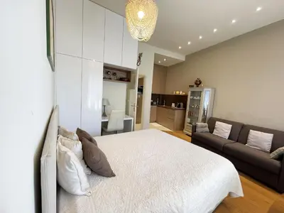a bedroom with a white bed and a couch at Ezevacances Studio Capuccino vue mer 5 mn plage 7 mn gare Wifi in Èze