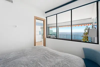 a bedroom with a large window with a view of the ocean at Balcon sur la Méditerranée in Nice