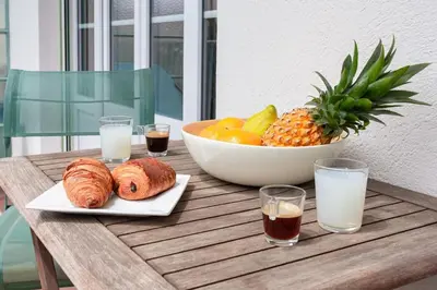 a table with a bowl of fruit and a plate of pastries at #7 What else ? Your own quiet terrace in Nice center 10min to Beach in Nice