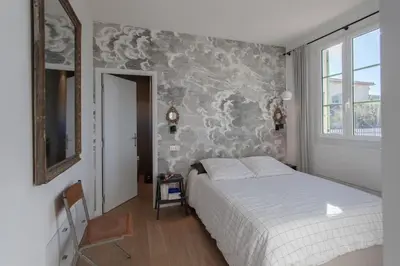 a bedroom with a bed and a window and a clock at #9 Opera's Duplex panoramic Sea View Terrace & AC 1min to Beach in Nice