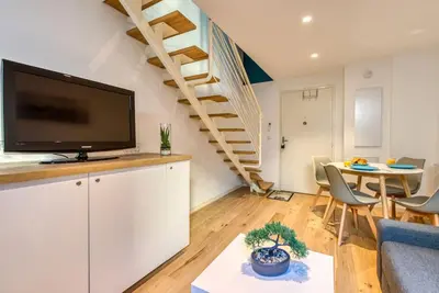 a living room with a flat screen tv and a staircase at #14 Duplex Tonduti terrace 5min Old Town in Nice