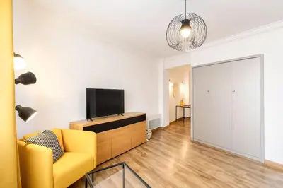 a living room with a yellow couch and a television at #1 Studio Fontaine de la Ville-WIFI in Nice