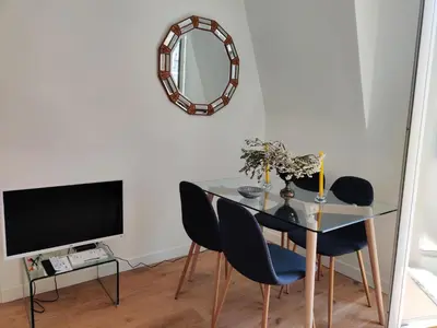 a dining room with a table and chairs and a mirror at Top floor nest, balcony close to sea and old-town Bail Mobilité in Nice
