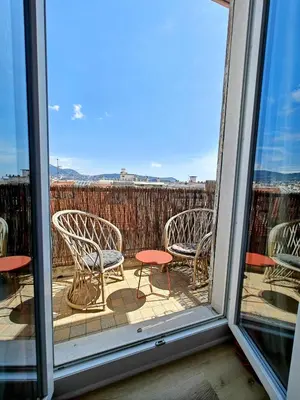 a balcony with chairs and tables and a window at Cozy roof terrace near Promenade des Anglais - AC in Nice