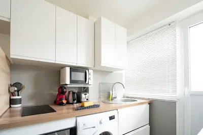 a kitchen with white cabinets and a sink at L'Azur Plaisance in Nice