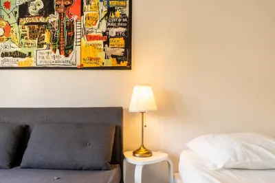 a bedroom with a bed with a lamp and a poster at L'Azur Plaisance in Nice