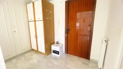 a hallway with a wooden door and a small cabinet at La Couronne du Cros in Cagnes-sur-Mer