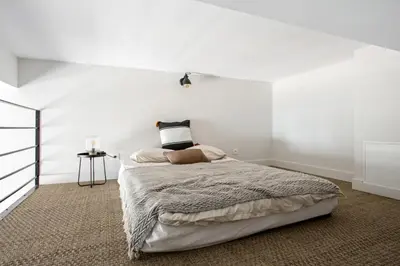 a bedroom with a bed with a white wall at Studio Francilia - Welkeys in Nice